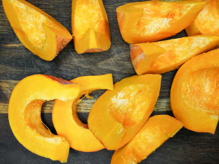 Autumn colors. Pumpkin slices on a wooden board. Fresh.の写真素材