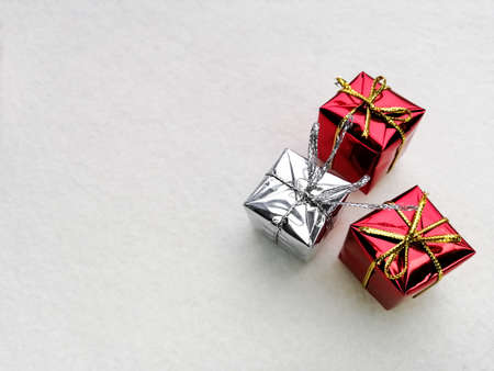 Three shiny Christmas gifts on white felt. White background, Christmas and New Year 'Day.の写真素材