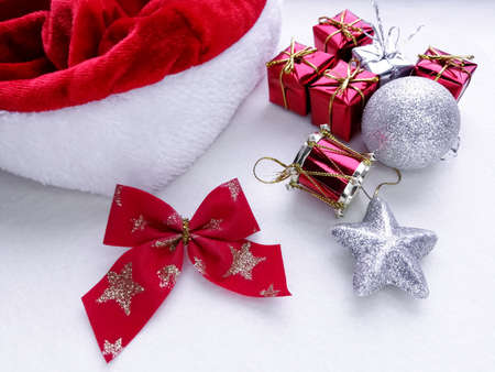 Festive composition - toys on the Christmas tree, Santa Claus hat and bow. Colors - gray, white and red. Christmas and New Year.の写真素材