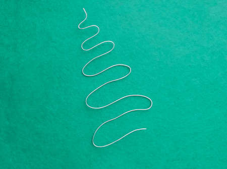 On the turquoise felt is a silver Herringbone made of soft wire. Christmas and New Yearの写真素材