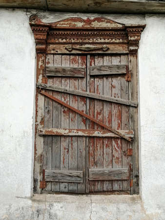 Old window. Boarded-up wooden window. Emergency house. Danger, without repair.の写真素材