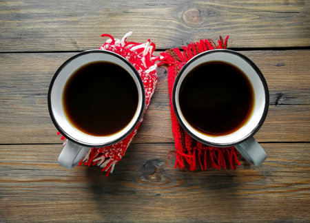 Two cups of Americano coffee on winter, knitted cup holders. The background is wooden. Winter comfort.の写真素材