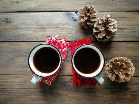On the wooden table are two cups of Americano and three cones. winter coziness. Christmas and New Year.の写真素材