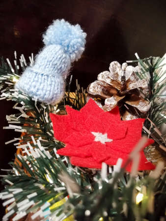Decorations for the New Year and Christmas. Christmas rose made of felt and knitted cap on an...