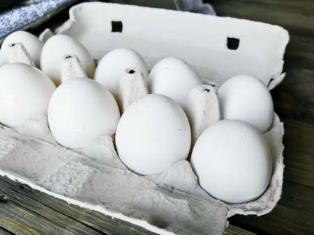 Homemade chicken eggs in a tray. 10 chicken eggs in a tray on a wooden table. Dirty chicken eggs....