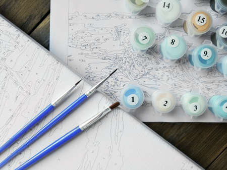 The artist's brushes and bright colors in jars for drawing on the picture by numbers or coloring by numbers. top viewの写真素材