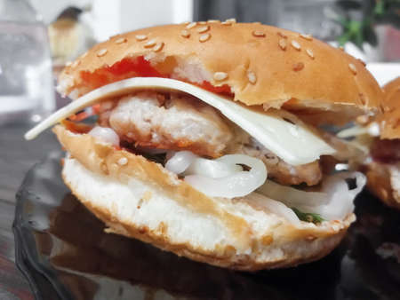 A large burger made at home from healthy products. A large hamburger with vegetables and meat at home.の写真素材