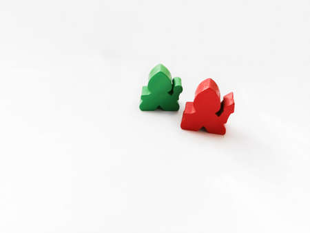 Two details from a child's play on a white background. Red and green details of the board game on a buel background. Wooden elements for the game.の写真素材