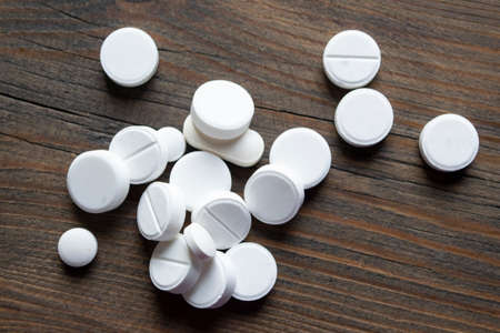 White pills on a wooden table. medical pills. traditional medicine. Tablets on a wooden background....