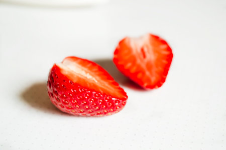 Cut in half strawberries. Ripe strawberries on a white background to the point. Dotted background and strawberries. Red from white. Red strawberries on white. beautiful berries. strawberry season.の写真素材