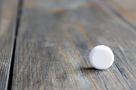 One round tablet on a wooden table. There is a white tablet on the tree. medicine and health. Tablets in our lives.の写真素材