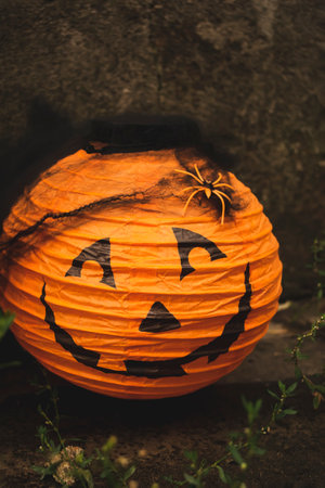 Jack lantern with a black web and an orange spider outside against the wall. Halloween. Halloween scenery is a jack lantern with a spider's web.の写真素材