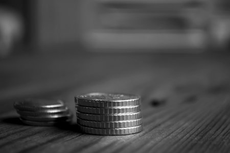 Two stacks of coins on a wooden table. Coins side macro shooting. Money on the table. iron denbgi lie in a stack.の写真素材