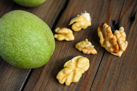 Walnuts on a wooden table. young walnuts. peeled walnut on a wooden table. Walnut in a green skin.の写真素材