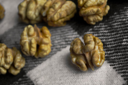 Walnuts peeled against the background in a cage. Peeled whole nuts. Whole peeled walnuts on a checkered, black background.の写真素材
