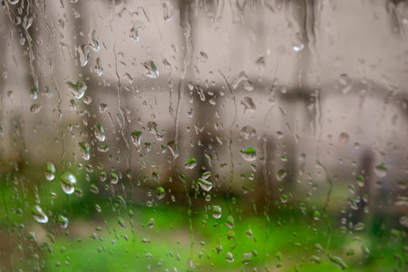 Raindrops on the glass. The window is in the raindrops. Water flows down the glass. Rain outside the window.の写真素材