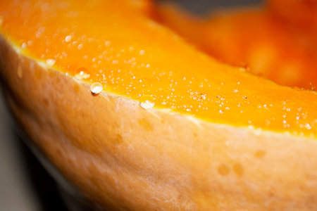 Drops of juice came out on a cut of the pumpkin. Juice on a cut of pumpkin. A piece with drops of juice. Shiny drops on a butchered pumpkin.の写真素材