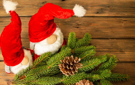 On a wooden table lie two Christmas gnomes next to the eldew. Decorations for the New Year and Christmas are dwarves. Red hats on Christmas gnomes.の写真素材