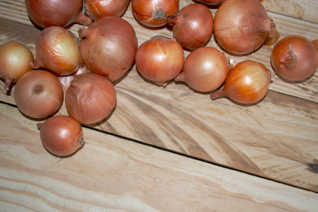 A lot of onions are on a wooden table. Wooden boards with onions. Stocks of onions. Onion heads on the table.の写真素材