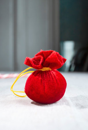 A red bag of gifts for Christmas and New Year is a toy. a small bag of dollars for the holidays. Santa Claus bag in miniature. A Christmas tree toy is a bag of textile gifts.の写真素材