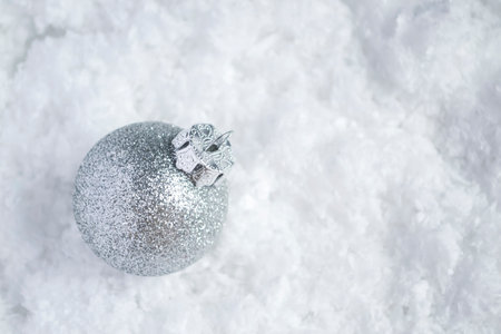 On the snow lies a glass Christmas ball on the tree. A toy on the Christmas tree is a ball with sparkles on white snow.の写真素材