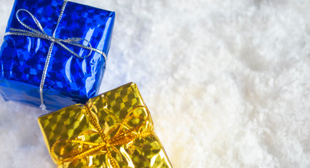 Christmas presents in the snow. Yellow-blue gifts on white snow. The symbol of Ukraine is yellow-blue, two gifts for the New Year and Christmas flowers of Ukraine.の写真素材