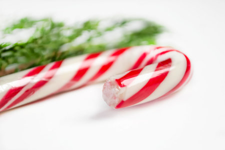 Christmas lozenge on a white table. candy cane lies at an angle on the table. Christmas and New Year.の写真素材