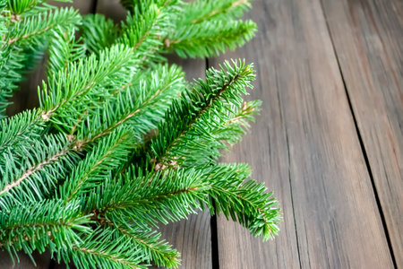Branches of a green spruce tree on a wooden table. Fluffy spruce with short needles on a wooden background.の写真素材
