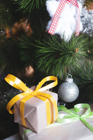 Gifts under the tree. Packaged gifts with colored ribbons lie under the Christmas tree.の写真素材