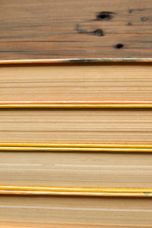 The books stand close together. Books on a wooden table. A stack of books with yellow covers.の写真素材