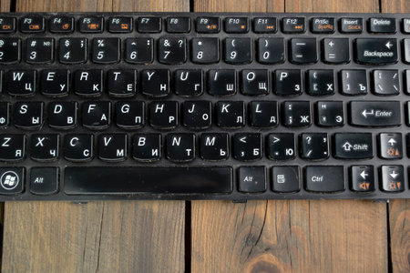 Cleaning the keyboard of the laptop. Dirty keyboard from a laptop on a wooden table.の写真素材