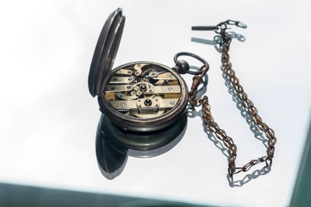 vintage clock. pocket, made of silver with a key for winding. Pocket watch on a mirror background....