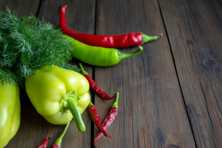 Different views of pepper and dill on the table. On the wooden table lies dill green t many types of sweet and hot peppers. Red and green pepper.の写真素材