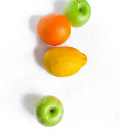 On the white lies orange, lemon and green apples. Healthy fruits on a white background. Healthy eating - bright fruits on white.の写真素材