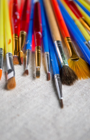 Lots of colored brushes for drawing. Brushes for artists on linen fabric. There are many artistic tassels on the fabric.の写真素材