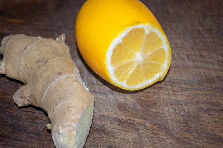 On a wooden board lies lemon and ginger. Ginger root and lemon. Fruits from the flu. For health, lemon and ginger root.の写真素材