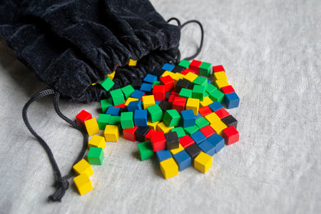 Game cubes in a black bag. Colored cubes poured out of the bag for the game. Lots of wooden cubes.の写真素材