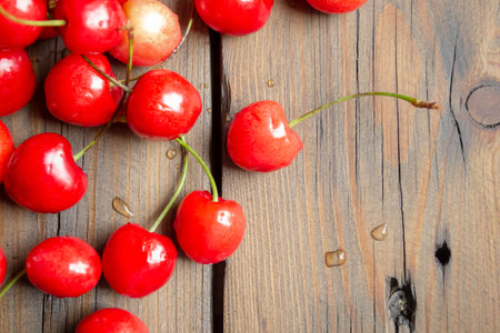 Cherry berries on a wooden table. Lots of fresh cherries. Beautiful berries of summer cherry. Healthy food - summer berries.の写真素材