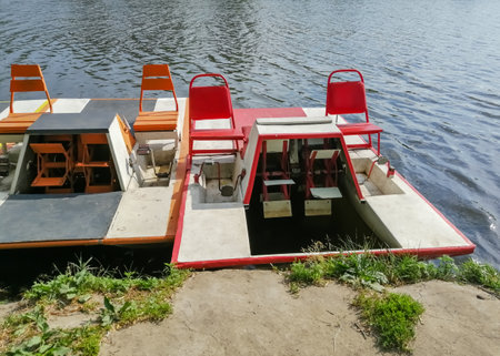 Catamarans stand on the river. On the lake there are old catamarans. Entertainment on the water. water boats for people.の写真素材