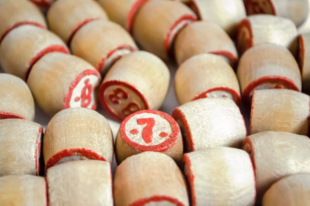 A lot of barrels from the lotto on a white background. Barrels are wooden with red numerals. Among the wooden barrels stands out with the number 7.の写真素材