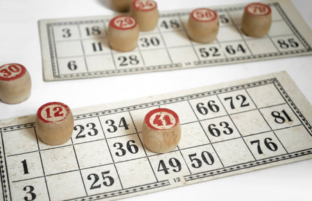 On the cards for the lotto there are barrels with numbers. Wooden barrels with numbers on lottoo cards. Board game in bingo.の写真素材