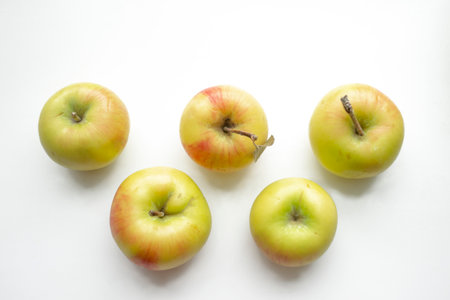 Apples in the form of Olympic symbols. Olympic rings made of apples. beautiful yellow apples on a white background.の写真素材