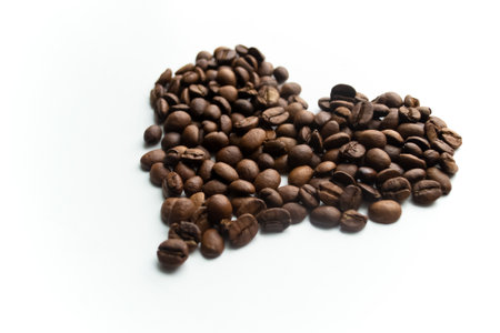 The heart is lined with coffee beans. Love of coffee. On a white background, a heart of coffee beans.の写真素材