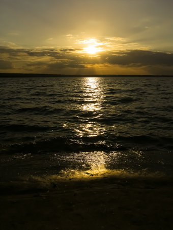 beautiful sunset. Orange sunset against the background of dark water. A path in the water from the sun. sunset on the river. Delightful. golden sunset.の写真素材