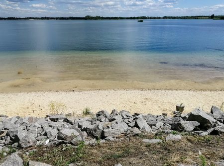 Stones, beach, river. View of the river from the beach. Beautiful landscape on the beach.の写真素材
