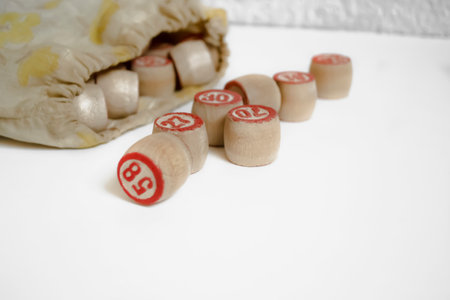 Bingo barrels on a white background. barrels of plates poured out of the bag for the lotto board game. Elements of a board game with numbers made of wood.の写真素材