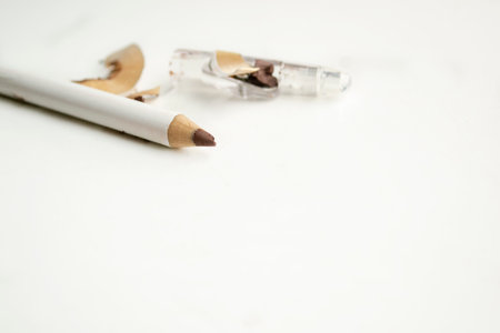 Make-up pencil on a white table. sharpened eye pencil. Eyeliner with a broken rod on a white background.の写真素材
