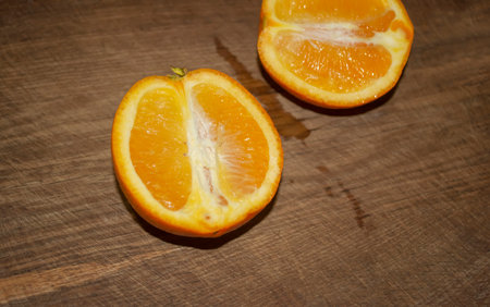 Halves of orange lie on a wooden table, Healthy citrus fruits - orange. On the board lies two halves of orange orange.の写真素材