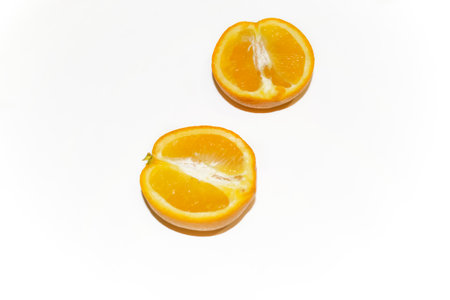 Orange on white - bright halves of citrus. Two halves of an orange on a white background.の写真素材