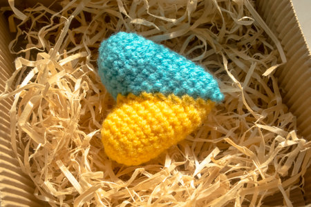 Knitted heart of yellow and blue colars in a gift box. gift - the heart of the colors of the flag of Ukraine. The symbol of Ukraine is a yellow-blue heart in a gift box in tinsel.の写真素材